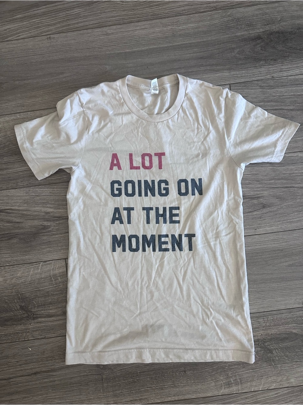 Graphic Tee "A LOT GOING ON AT THE MOMENT" - cream with red & black Text